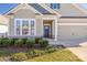 Charming one-story home with blue front door, landscaped front yard and attached two car garage at 106 Chase Water Dr, Mooresville, NC 28117