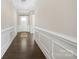 Inviting hallway with white wainscoting, hardwood floors, and white front door at 106 Chase Water Dr, Mooresville, NC 28117