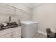 Functional laundry room with granite countertops, stainless steel sink, washer, dryer, and storage shelving at 106 Chase Water Dr, Mooresville, NC 28117