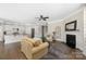 Open-concept living room with fireplace and direct access to modern kitchen with stainless steel appliances at 106 Chase Water Dr, Mooresville, NC 28117