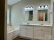 Bathroom with dual sink vanity, framed mirrors, lighting, and soaking tub at 11339 Fox Hill Dr, Charlotte, NC 28269