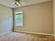 Simple bedroom with neutral paint, carpet, and a window for natural light at 11339 Fox Hill Dr, Charlotte, NC 28269
