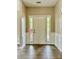 Bright foyer with wood-look flooring, white trim, and a view of outdoor greenery through sidelight windows at 11339 Fox Hill Dr, Charlotte, NC 28269