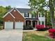 Charming two-story home with a brick facade, lush landscaping, and a two-car garage at 11339 Fox Hill Dr, Charlotte, NC 28269