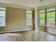 Sunlit living room featuring wood floors, neutral paint, and large windows overlooking the front yard at 11339 Fox Hill Dr, Charlotte, NC 28269