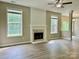 Spacious living room featuring a fireplace, ceiling fan, wood-look floors, and natural light from several windows at 11339 Fox Hill Dr, Charlotte, NC 28269