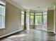 Sunlit living room featuring wood floors, neutral paint, and large windows overlooking the front yard at 11339 Fox Hill Dr, Charlotte, NC 28269