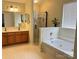 Bright bathroom featuring a jacuzzi tub, walk-in shower with a glass door, and double sinks with a vanity at 14809 Castletown House Dr, Charlotte, NC 28273