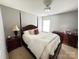 Bedroom with a dark wood four-poster bed, matching dresser and nightstand with lamp at 14809 Castletown House Dr, Charlotte, NC 28273