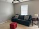 Comfortable living room with a blue sofa, patterned pillows, and a round side table with a lamp at 14809 Castletown House Dr, Charlotte, NC 28273