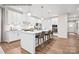 Modern kitchen features white cabinets, stainless appliances, island with seating, and hardwood floors at 1809 Ab Moore Jr Dr # 3238, Indian Trail, NC 28079