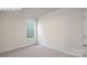 Neat bedroom features neutral carpet, white trim, and a window for natural light at 2016 Skyhawk Dr, Lake Wylie, SC 29745