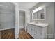 Bright bathroom vanity with marble countertop next to a walk-in closet and shower at 2500 Cranbrook Ln # 5, Charlotte, NC 28207