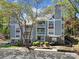 Three-story condo with a mix of gray siding, brick accents, and balconies surrounded by mature trees at 2500 Cranbrook Ln # 5, Charlotte, NC 28207