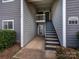 Condo entrance with stairs, gray siding, and well-maintained landscaping, leading to a cozy home at 2900 Heathstead Pl # A, Charlotte, NC 28210