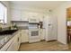 Well-lit kitchen with white cabinetry, granite countertops, and modern appliances for convenient cooking at 2900 Heathstead Pl # A, Charlotte, NC 28210
