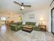 Open-concept living area with a large green sectional sofa, ceiling fan and laminate flooring at 2900 Heathstead Pl # A, Charlotte, NC 28210