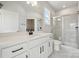 Bright bathroom with quartz countertops, a walk-in shower, and white marble tile at 304 Balboa St, Matthews, NC 28104