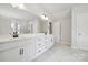 Bright bathroom featuring double sink vanity with white cabinets, black hardware, and marble style flooring at 304 Balboa St, Matthews, NC 28104