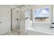 Modern bathroom with sleek glass-enclosed shower, white soaking tub, and a bright window overlooking the outdoors at 304 Balboa St, Matthews, NC 28104