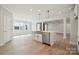 Modern kitchen with an island, stainless steel appliances, and hardwood floors, seamlessly connecting to the living room at 304 Balboa St, Matthews, NC 28104