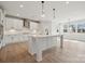 Modern white kitchen with an island, pendant lighting, stainless steel appliances, and hardwood floors at 304 Balboa St, Matthews, NC 28104