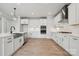Modern kitchen featuring stainless steel appliances, white cabinetry, an island, and hardwood floors at 304 Balboa St, Matthews, NC 28104