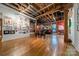 An expansive living room features exposed brick, wooden beams, and beautiful wood flooring at 310 Arlington Ave # Multiple, Charlotte, NC 28203