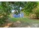 View of the home's backyard featuring an expansive lawn and trees providing shade on a sunny day at 332 Mountain View St, Gastonia, NC 28052
