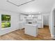 Bright kitchen features an island, white cabinets, stainless steel fixtures, and hardwood flooring at 332 Mountain View St, Gastonia, NC 28052