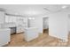 Bright kitchen features an island, white cabinets, stainless steel fixtures, and hardwood flooring at 332 Mountain View St, Gastonia, NC 28052