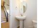 Stylish half bathroom featuring pedestal sink and decorative mirror at 3924 Craig Ave, Charlotte, NC 28211
