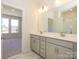 Bathroom featuring double vanity, framed mirror, and view to bedroom and shower at 3924 Craig Ave, Charlotte, NC 28211
