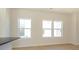 Sunlit living room with hardwood floors, white trim, and large windows at 3924 Craig Ave, Charlotte, NC 28211