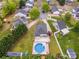 Bird's eye view of a neighborhood displaying homes with green lawns and a home with a swimming pool and backyard at 406 Llewellyn St, Belmont, NC 28012