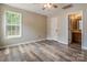 Light-filled bedroom featuring wood-look floors, a ceiling fan, and access to an ensuite bathroom at 406 Llewellyn St, Belmont, NC 28012