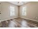 Cozy bedroom features wood-look floors, a ceiling fan, and dual windows for natural light at 406 Llewellyn St, Belmont, NC 28012