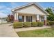 Charming home featuring a covered front porch and well-maintained landscaping with manicured shrubbery at 406 Llewellyn St, Belmont, NC 28012