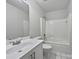 Clean bathroom with a white vanity, a shower-tub combo, and black and white tiled floor at 414 Fox Fire Run, Gastonia, NC 28052