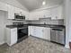 Modern kitchen with stainless steel appliances, white cabinets, and gray countertops for a sleek look at 414 Fox Fire Run, Gastonia, NC 28052