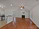 Open-concept living room with a fireplace, stainless steel appliances, and wood flooring at 414 Fox Fire Run, Gastonia, NC 28052