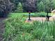 A charming backyard features a brick patio, lush garden beds with colorful flowers, and mature trees, perfect for relaxation at 4522 Long Cove Dr, Denver, NC 28037