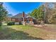 The backyard of this brick home boasts a wooden deck, brick patio, a sprawling lawn, and mature trees, perfect for entertaining at 4522 Long Cove Dr, Denver, NC 28037