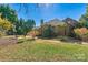 This home showcases a spacious backyard, featuring a brick patio, a wooden deck, and beautiful landscaping surrounded by mature trees at 4522 Long Cove Dr, Denver, NC 28037