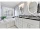 A light-filled bathroom features a double sink vanity with a marbled countertop and a glass block window at 4522 Long Cove Dr, Denver, NC 28037