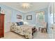Cozy bedroom features light blue walls, a floral-patterned bedspread, and a window letting in natural light at 4522 Long Cove Dr, Denver, NC 28037