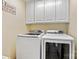 Well-equipped laundry room with white washer and dryer and overhead cabinets for efficient organization and storage at 4522 Long Cove Dr, Denver, NC 28037