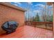 Deck with wooden flooring, grill, and lush backyard scenery under blue sky at 4605 Curraghmore Rd, Charlotte, NC 28210