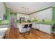 Bright kitchen features an island, white cabinets, stainless steel appliances, and hardwood floors at 4605 Curraghmore Rd, Charlotte, NC 28210