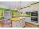 Spacious kitchen features an island, white cabinets, stainless steel appliances, and hardwood floors at 4605 Curraghmore Rd, Charlotte, NC 28210